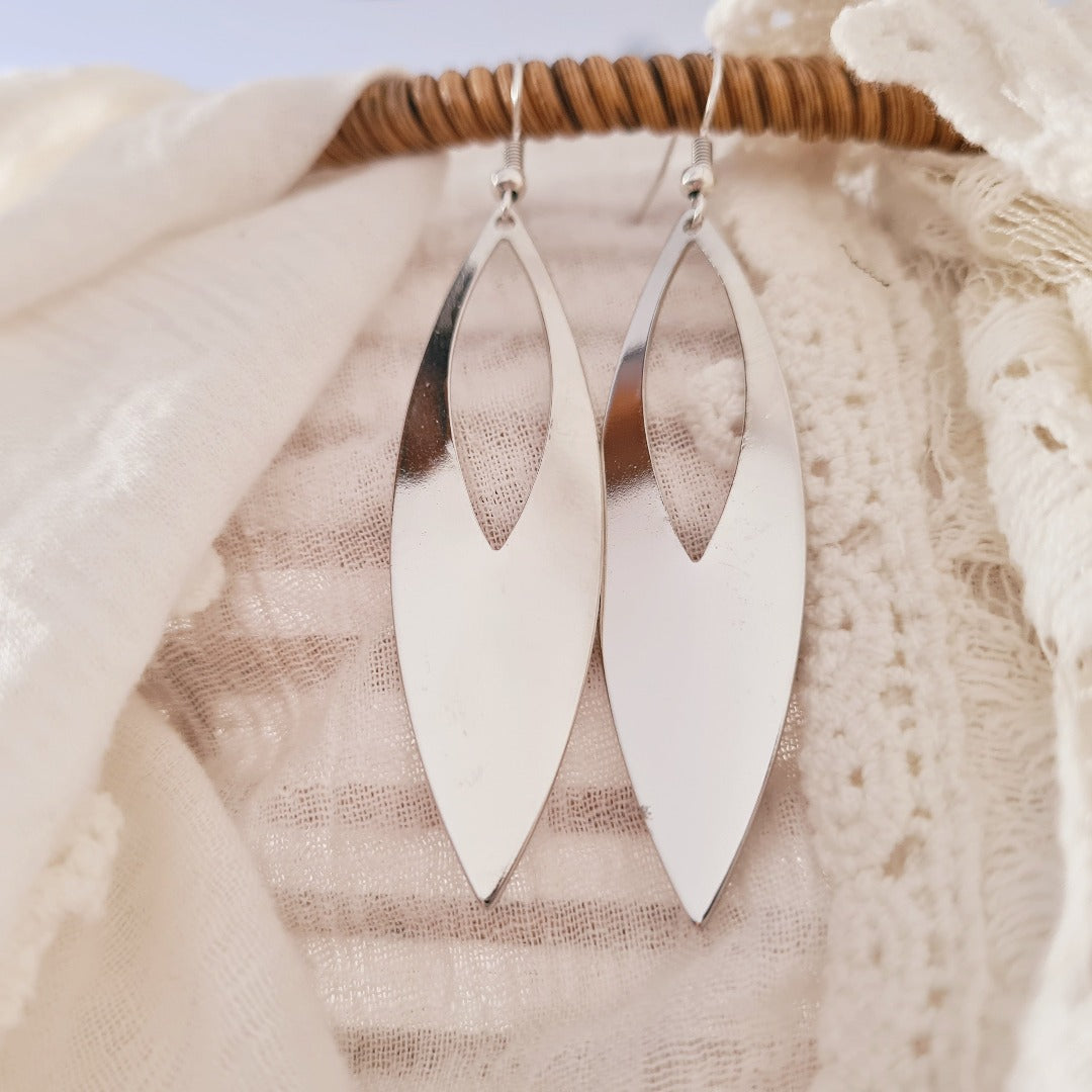 Elegante lange zilveren oorbellen met open bladvorm