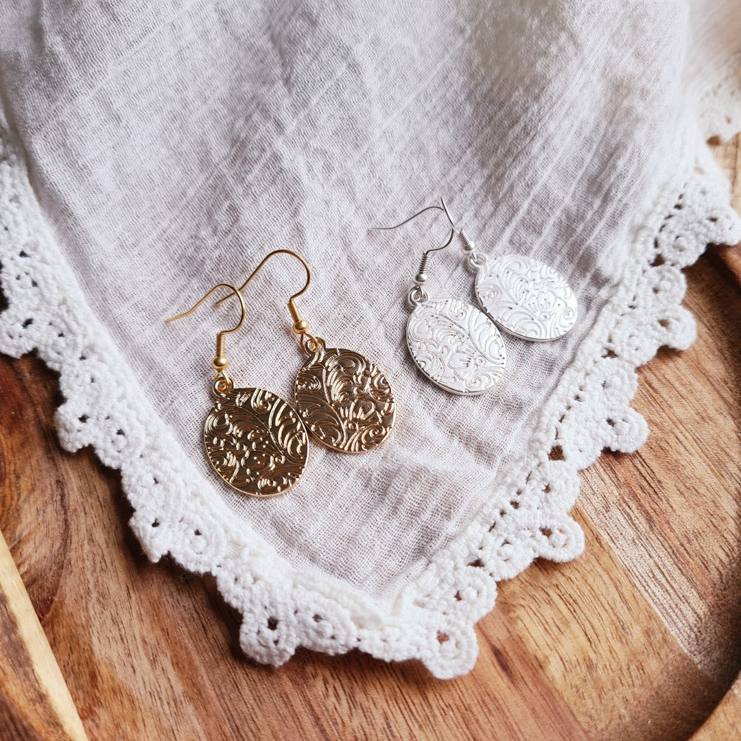 Zilverkleurige ovale munt oorbellen met reliëf