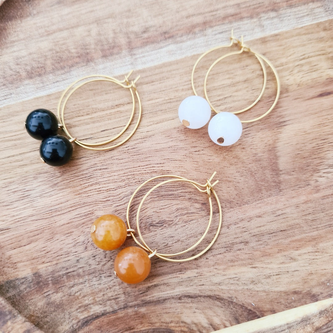 Gouden oorbel met echte edelsteen in warme oranjetint, subtiel en tijdloos