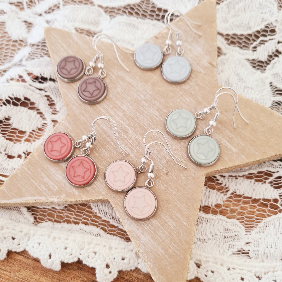 Zilverkleurige oorbellen met roze sterbedel