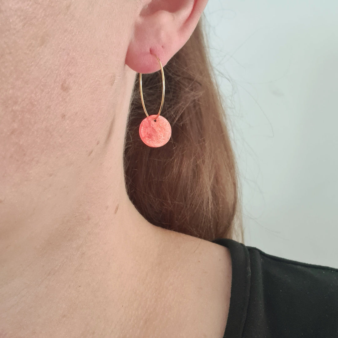 Ringen van stainless steel in goud met oranje resin bedel