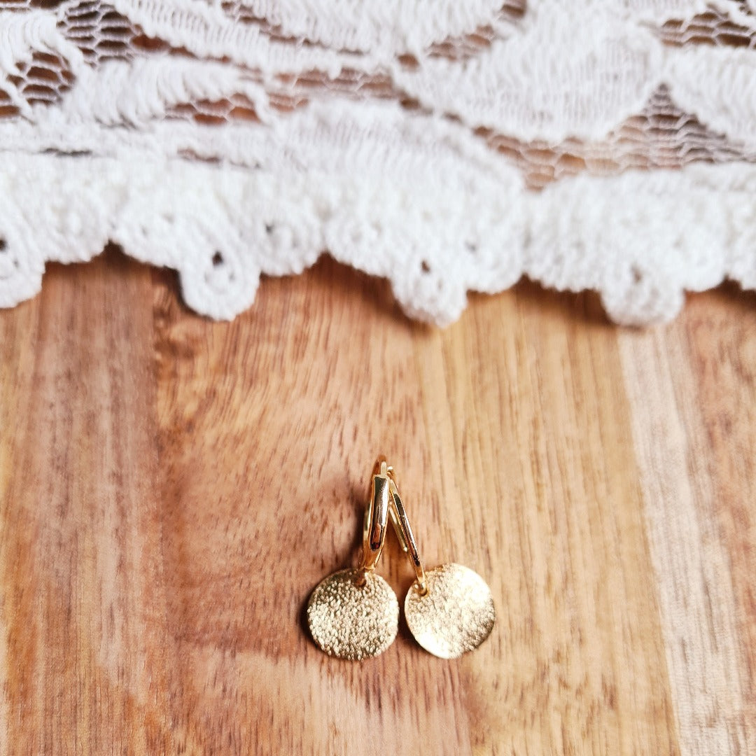 Gouden ringetjes met feestelijke ronde hangertjes en een subtiel reliëf