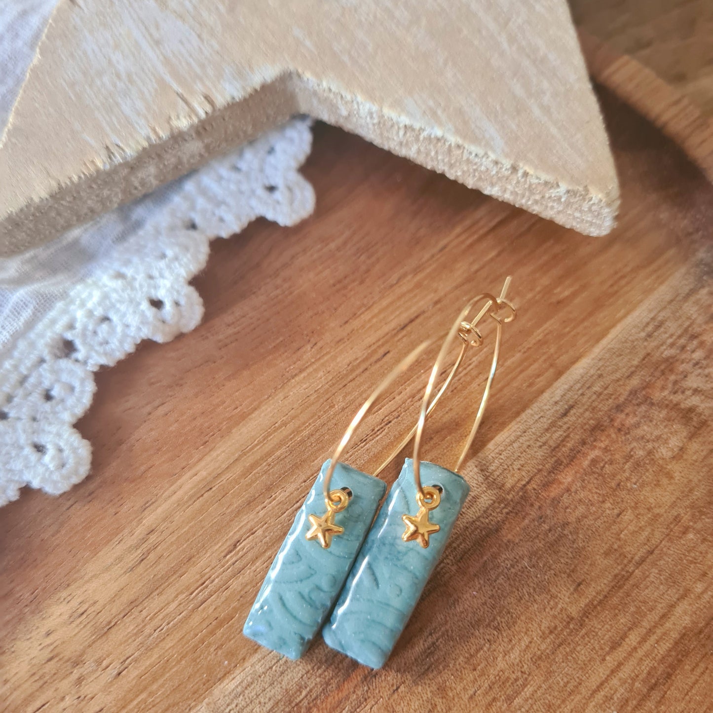 Handgemaakte polymeerklei oorbellen lichtblauw goud sterretje gedragen, minimalistische oorbellen