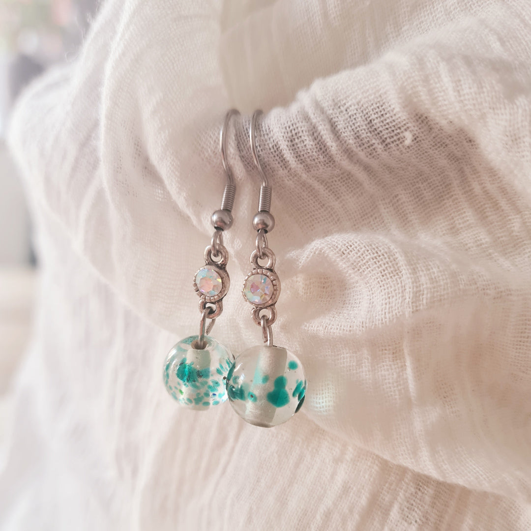 Zilverkleurige oorbellen met groene glaskraal en elegante afwerking