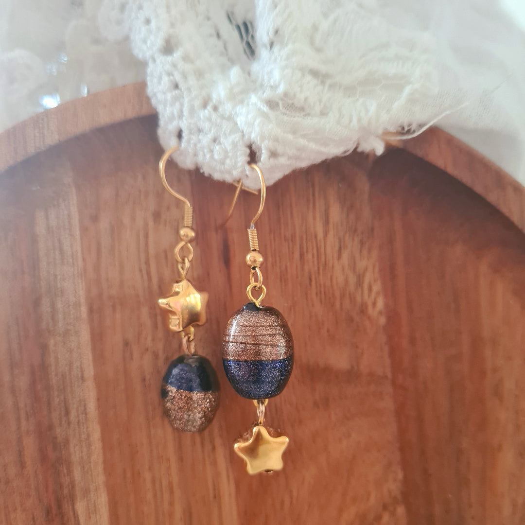 One of a kind oorbellen met diepblauwe glaskraal en gouden ster