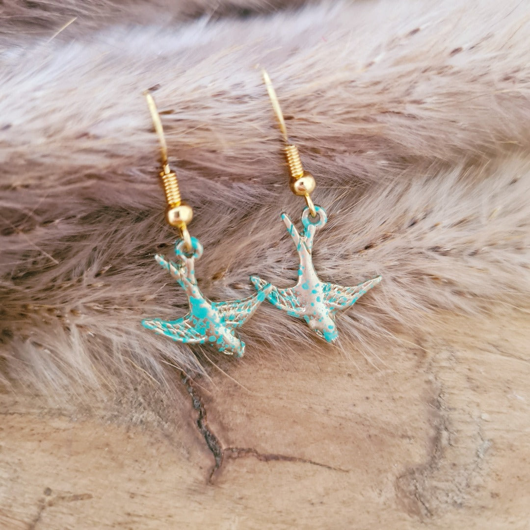 Gouden vogel oorbellen met turquoise bedel, close-up productfoto nikkelvrij