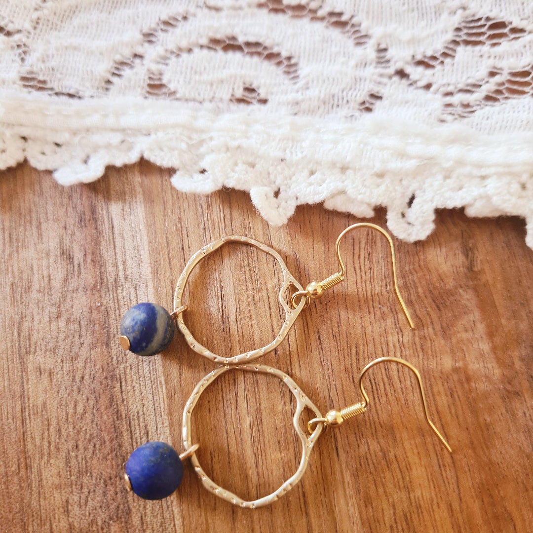 Oorbellen met goudkleurige ring en blauwe frosted steen