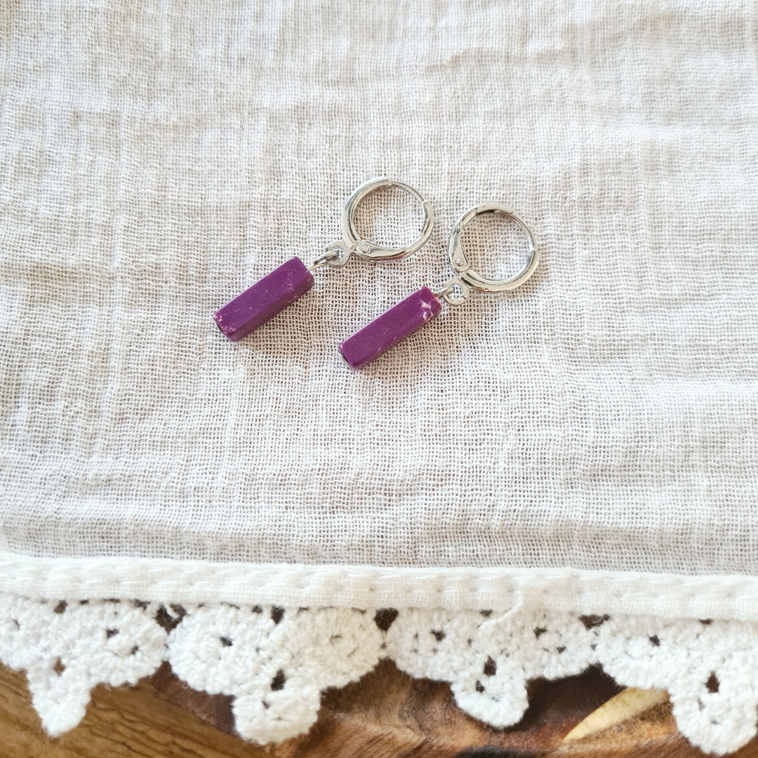 Zilverkleurige oorbellen met smal paars staafje van regaliet aan klapring