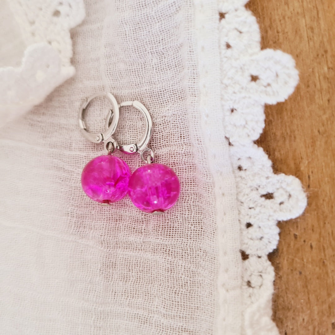 Detail zilverkleurige ringetjes met fuchsia roze kraal kliksluiting nikkelvrij metaal
