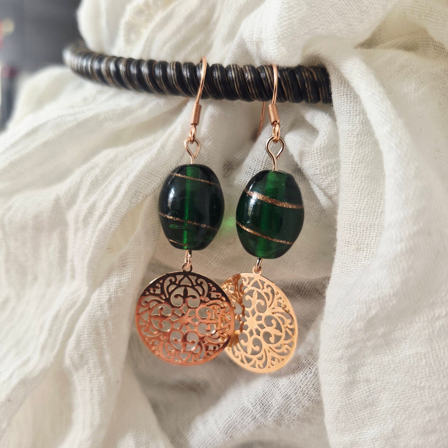 One of a kind oorbellen groene glaskraal met roségouden boho bedel