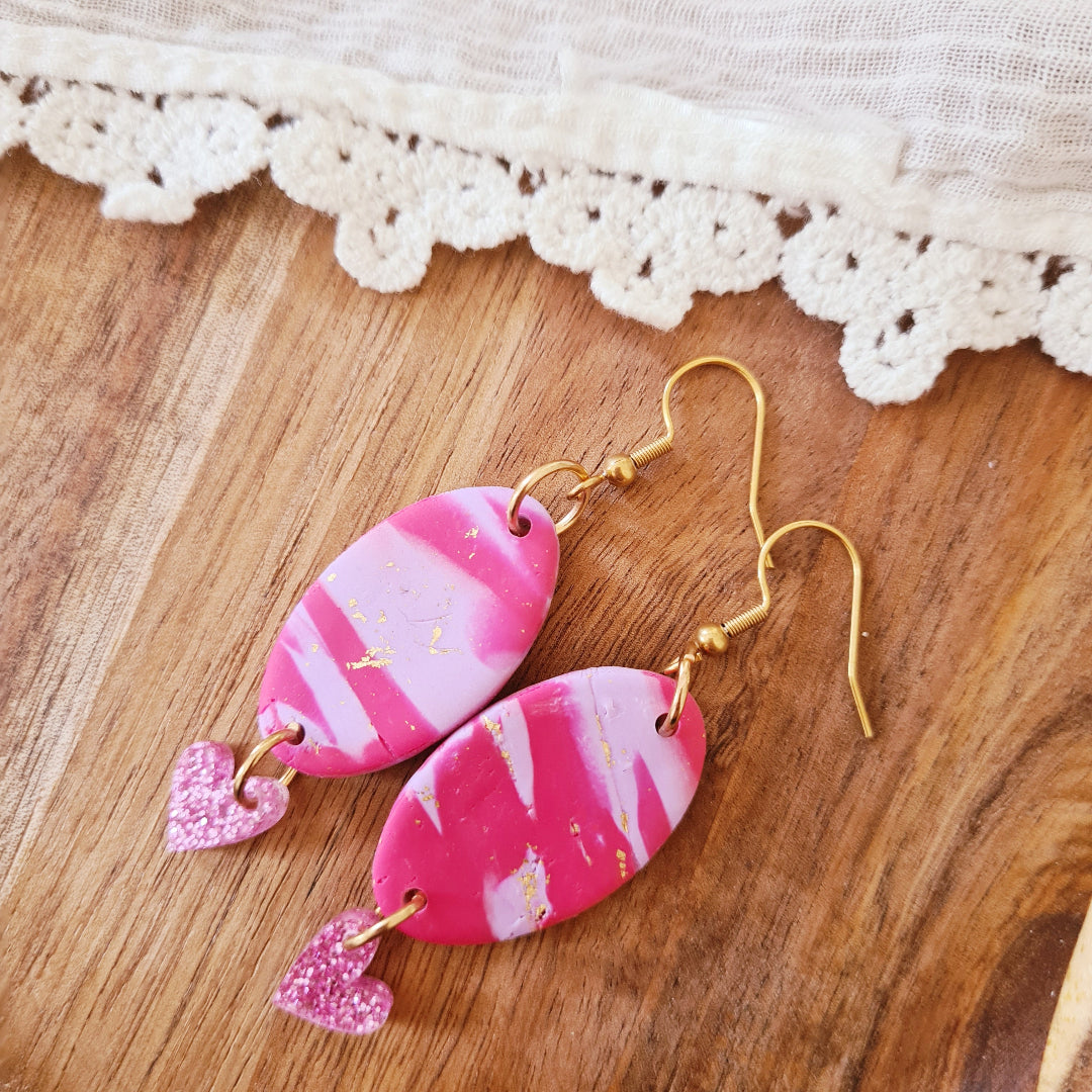 Handgemaakte ovale oorbellen met roze-lila marmerlook en glitterhartje