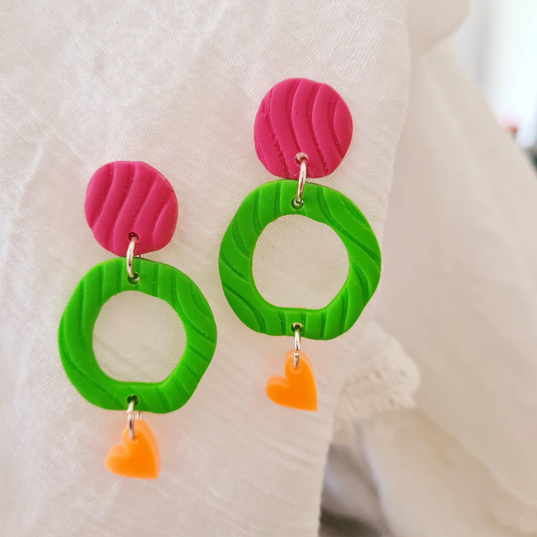 Vrolijk paar klei oorbellen met ronde vormen en oranje hangertje