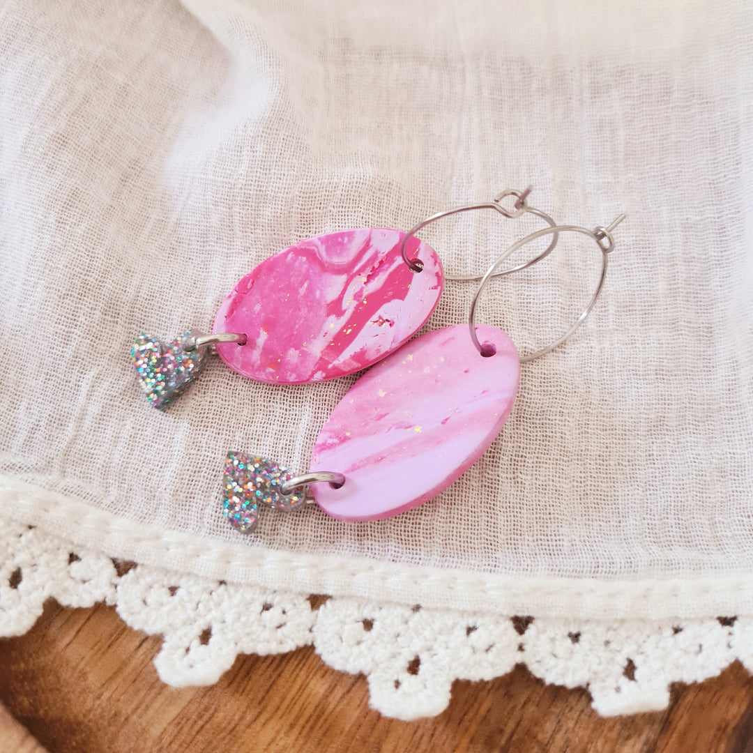 Uniek paar roze-lila oorbellen met zwartglitter detail onderaan