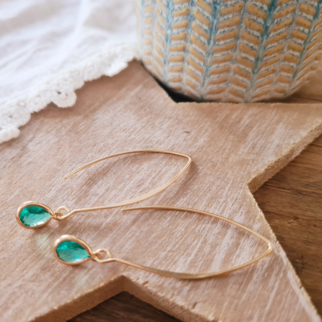 Goudkleurige oorbellen met blauwe kristalglas druppel