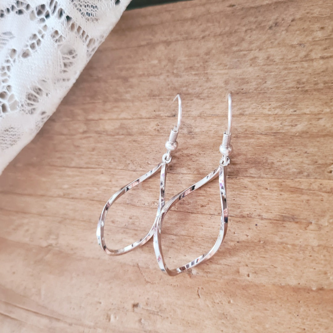 Gedraaide zilverkleurige druppel oorbellen – elegant met een speelse twist