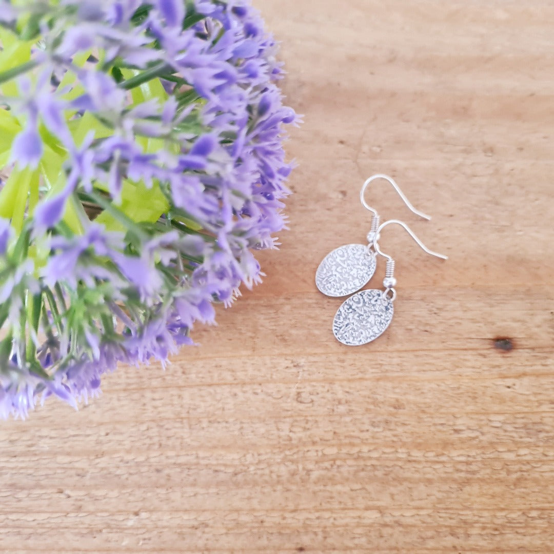 Zilveren oorbellen met gegraveerde ovale hanger