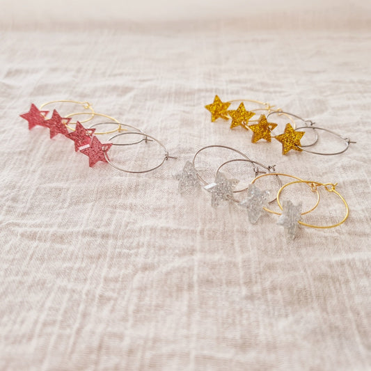 Gouden ringen van stainless steel met plex ster bedel in roze glitter