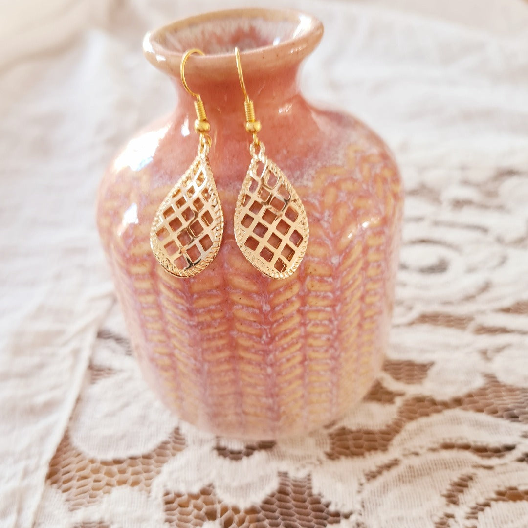 Gouden lichte druppel oorbellen met een twist