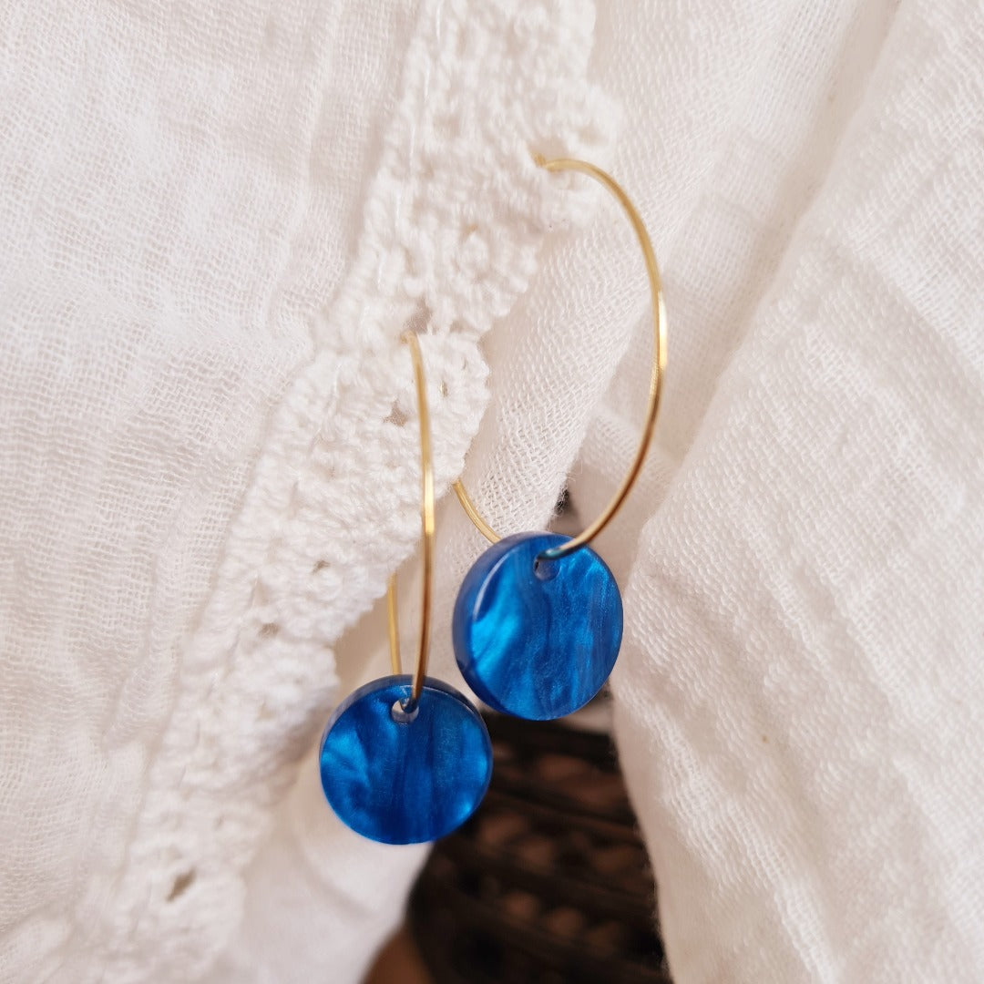 Gouden ringen met blauwe resin bedel