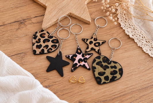 Sleutelhangers met leopardprint in hartvorm en stervorm, een zwarte ster en goudkleurige hartjes oorstekers