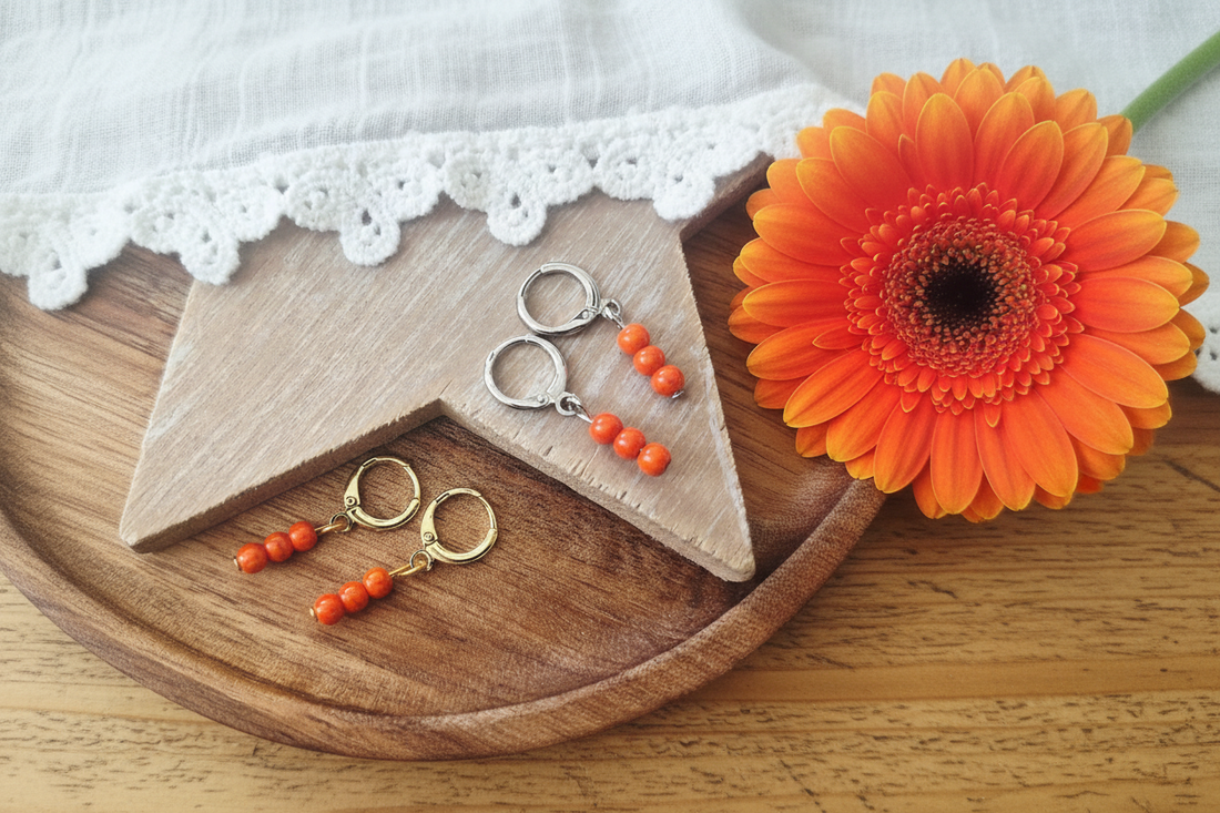 ringetjes in goud en zilver met oranje kraaltjes