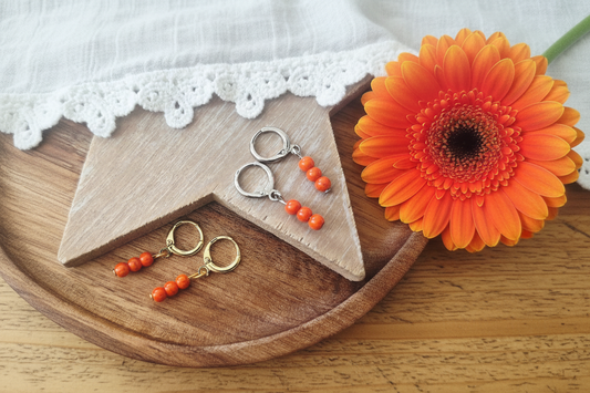 ringetjes in goud en zilver met oranje kraaltjes