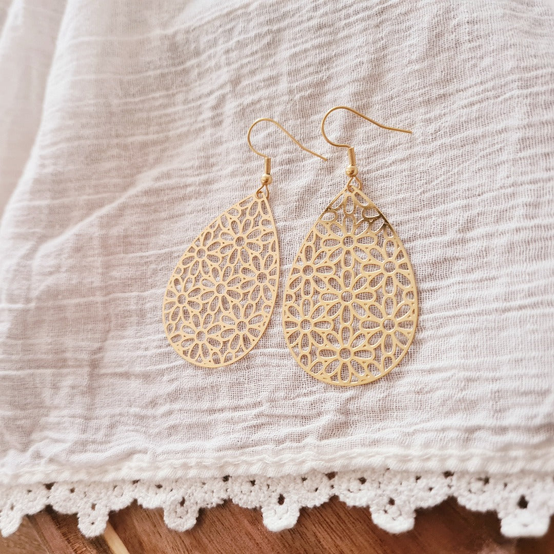 Grote gouden druppel oorbellen met verfijnd bloemmotief