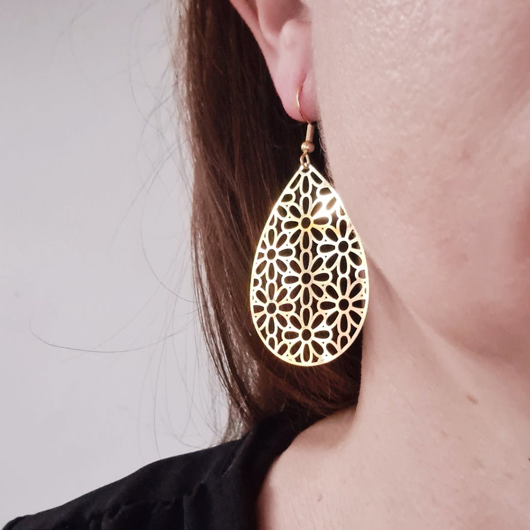 Grote gouden druppel oorbellen met verfijnd bloemmotief