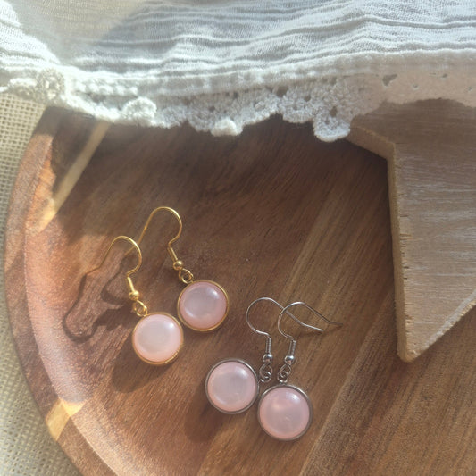 Korte hangertjes met lichtroze steentje in goud en zilver