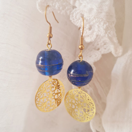 One of a kind oorbellen met gouden bedel en kobaltblauwe glaskraal
