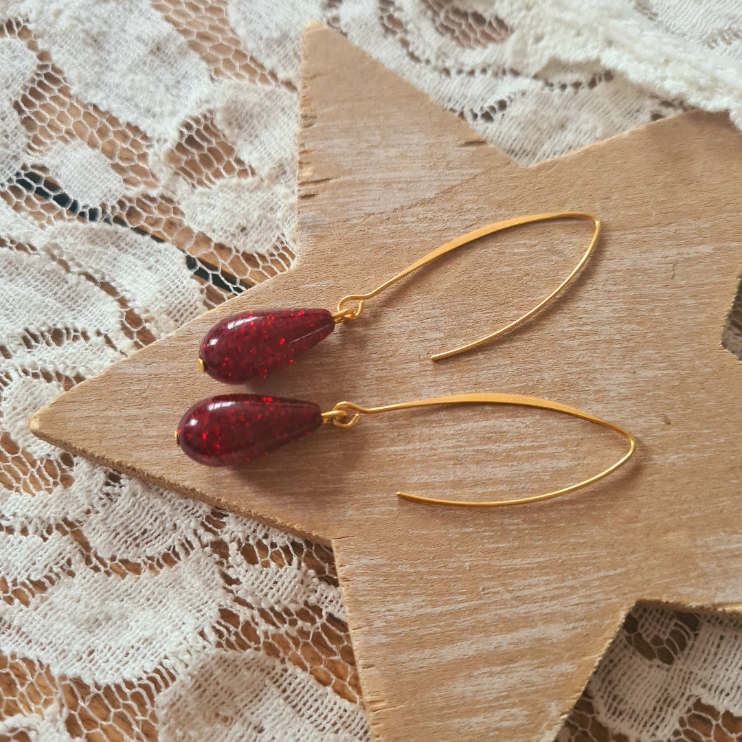 Lange oorbellen in goud met bordeaux druppelvormige hanger
