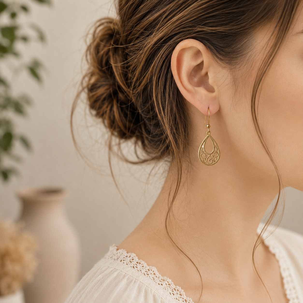 Model draagt mooie bohemian druppel oorbellen in goud