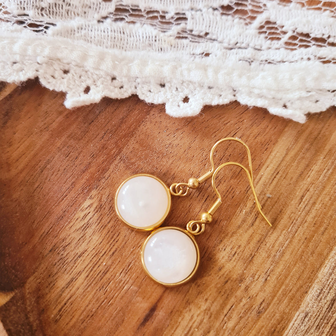 Goudkleurige oorbellen met ronde witte steen