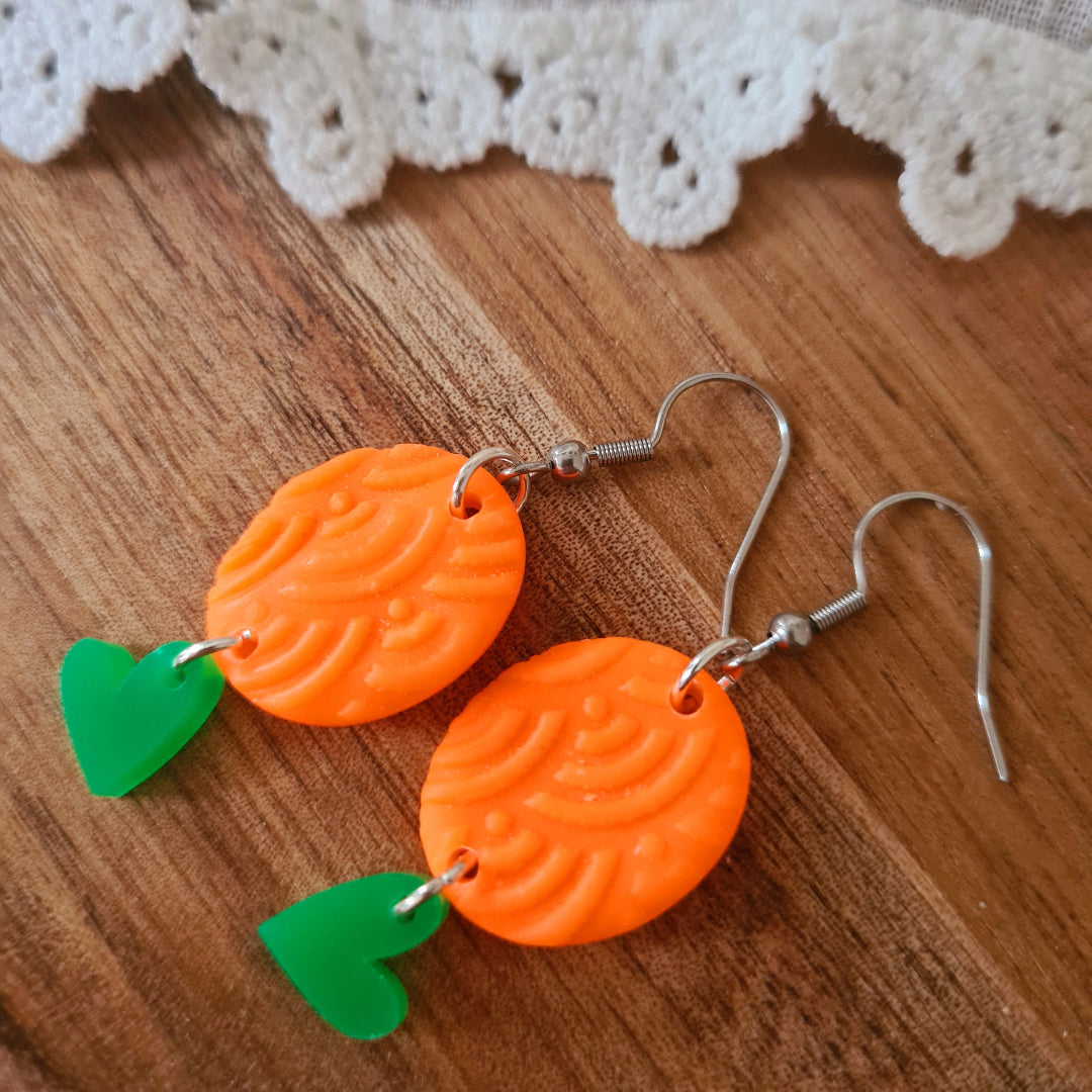 Unieke polymeerklei oorbellen met oranje bedel en groen plex hartje