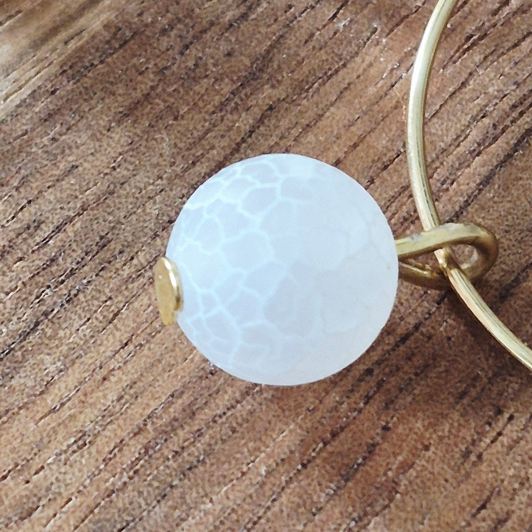Witte crackle chalcedoon steen detail goudkleurige ringetjes stainless steel oorbellen