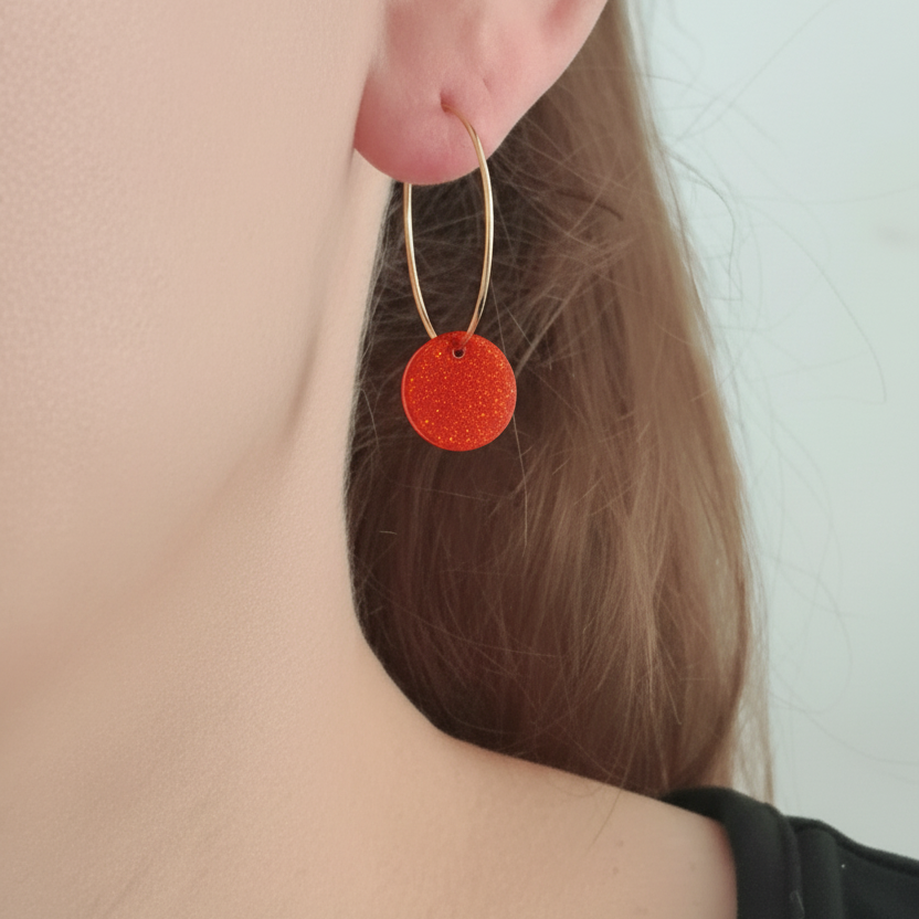 Gedragen donkere oranje-rode resin oorbel op model