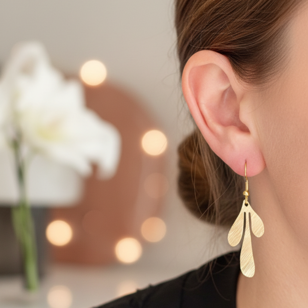 Gouden blad oorbellen op gekleed model