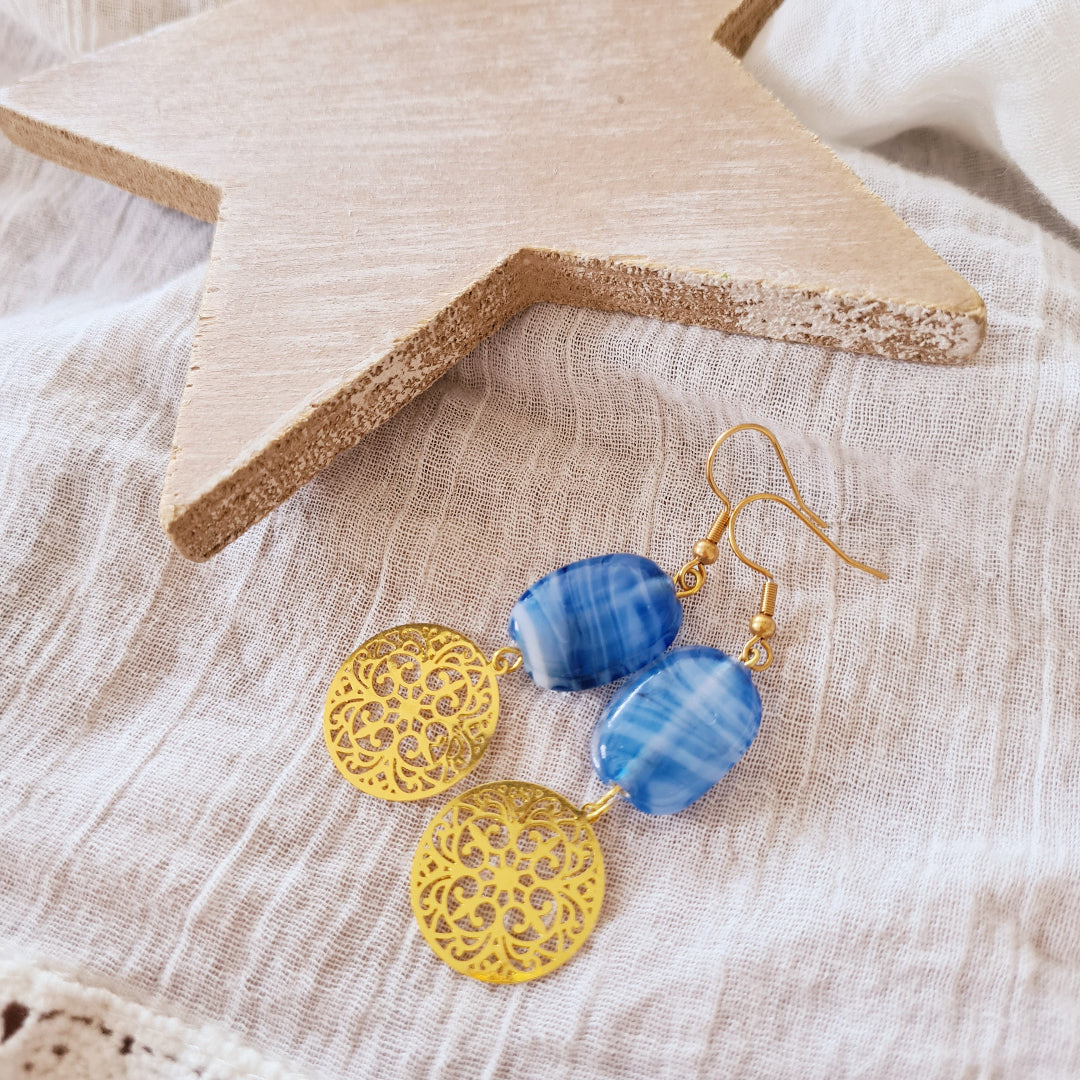 Oorbellen met blauwe glaskraal en gouden bedel van Little Suzies