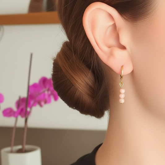 Gouden ringetjes met roze kraaltjes gedragen door model