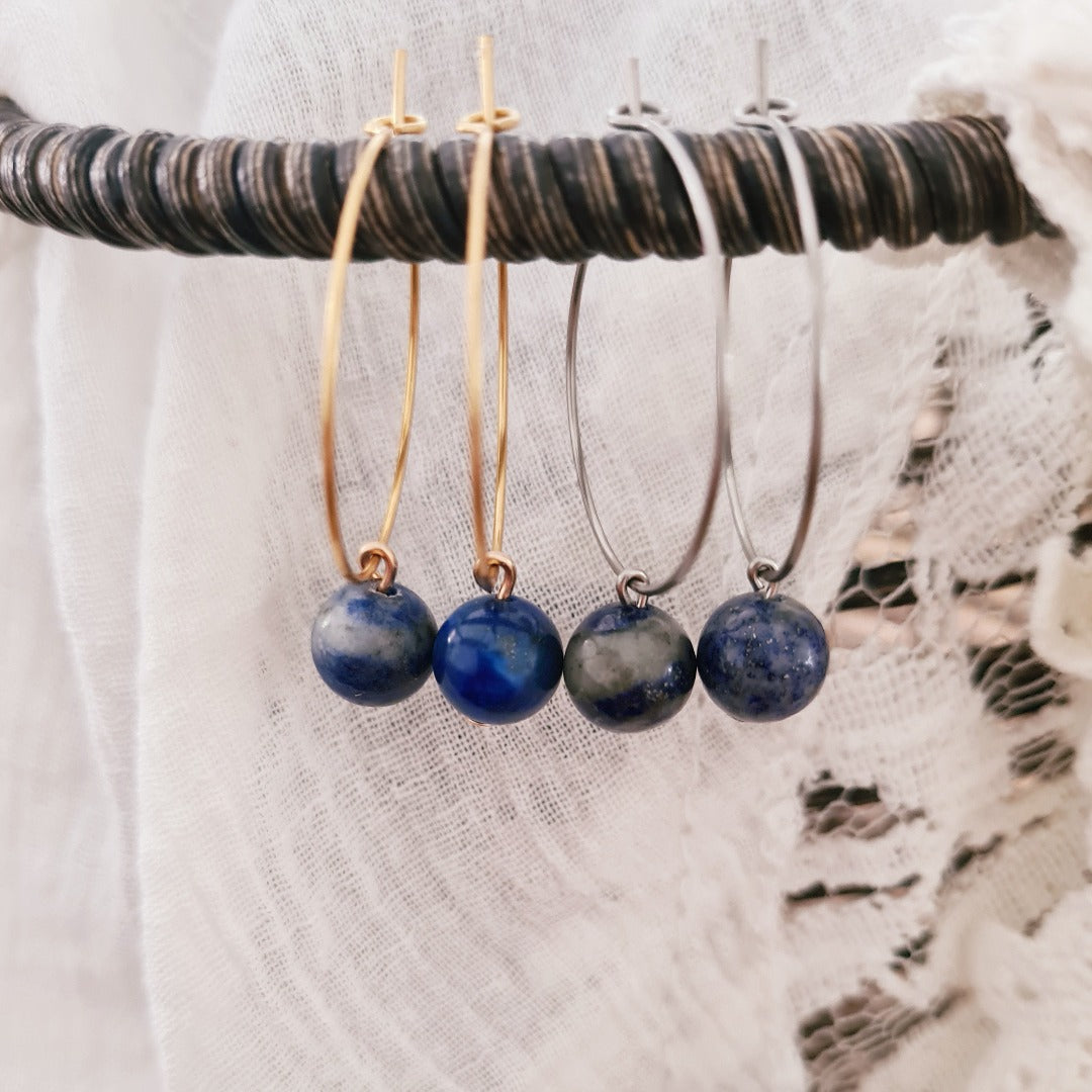 Gouden en zilveren ringen met lapis lazuli steentje naast elkaar