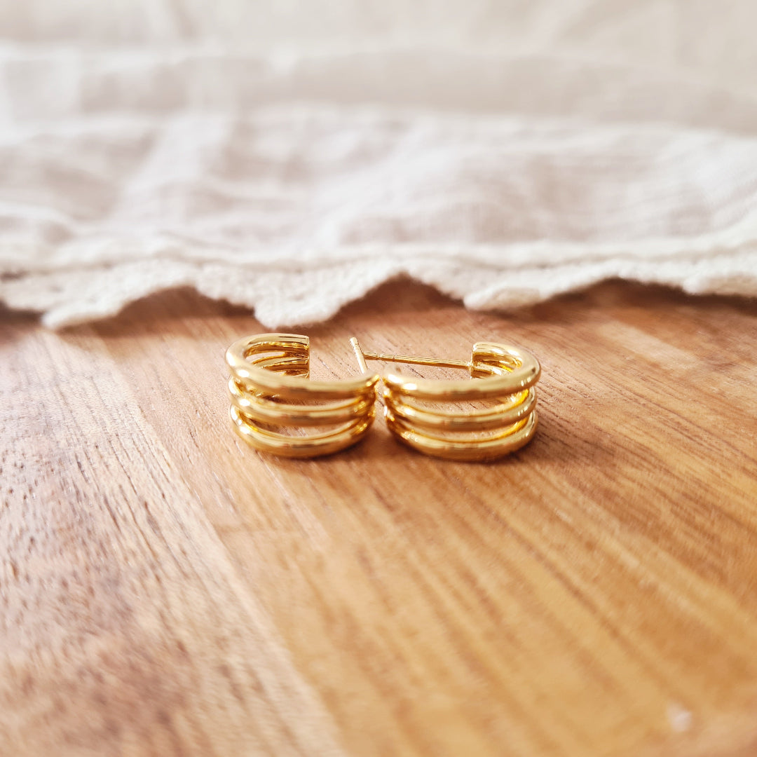 Oorbel met drie goudkleurige ringetjes in één steker van stainless steel