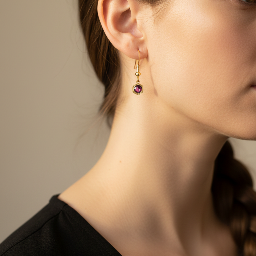 Goudkleurige donkerroze paarse geboortesteenoorbel februari - gedragen