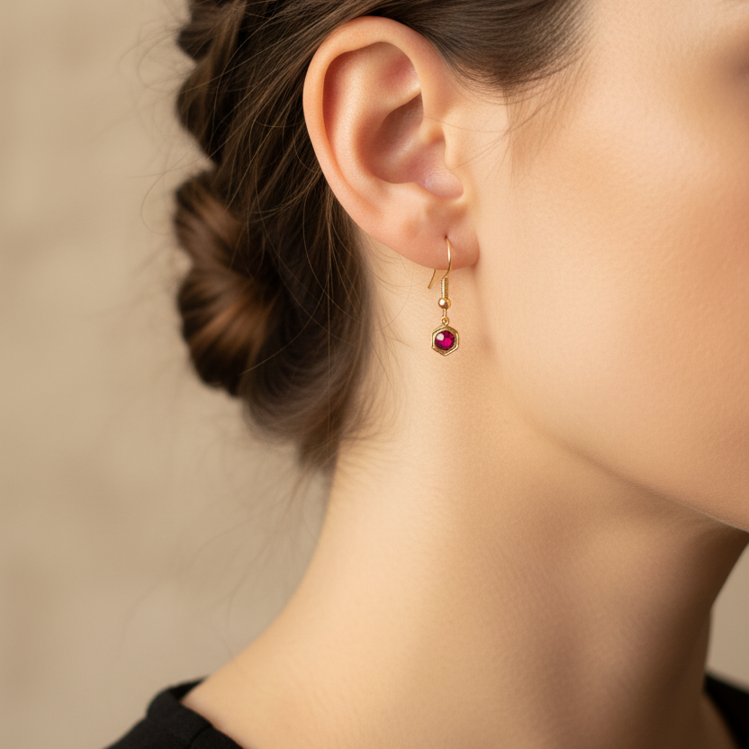 Goudkleurige robijnroze geboortesteenoorbel juli - gedragen zonder oog