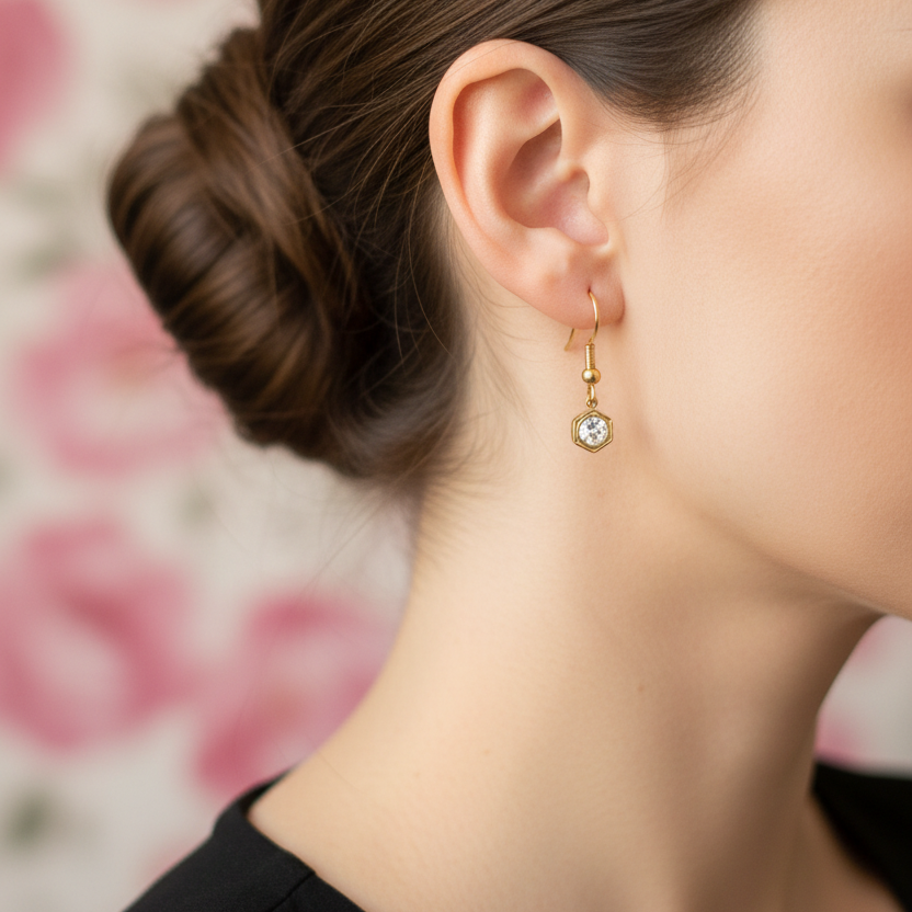 Goudkleurige transparante geboortesteenoorbel april - gedragen