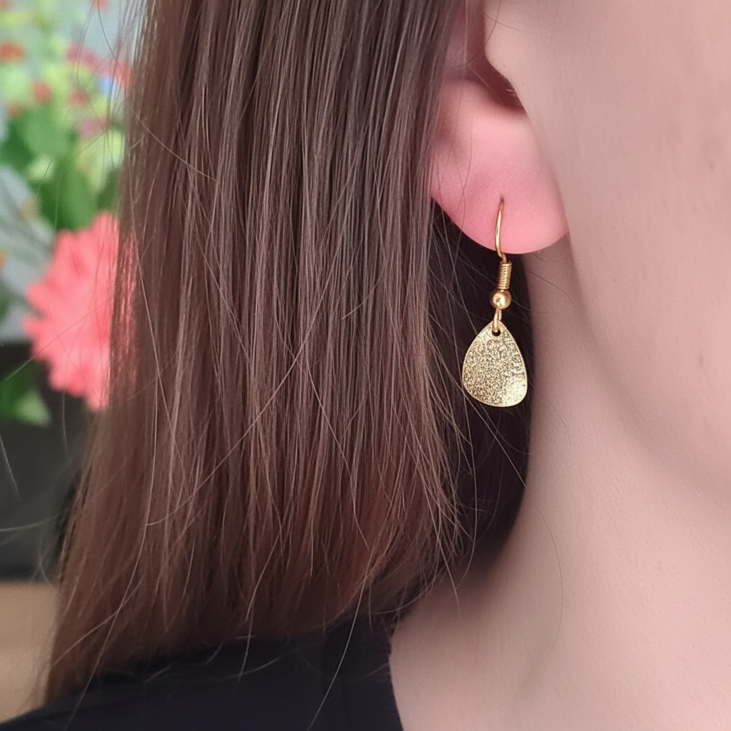 Kleine gouden druppeloorbellen gedragen