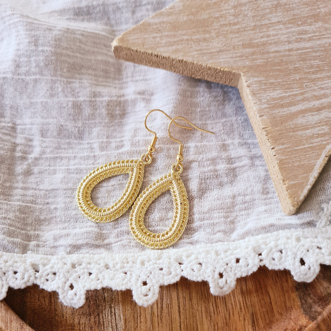 Medium gouden druppel oorbellen gedragen, tijdloze elegante look