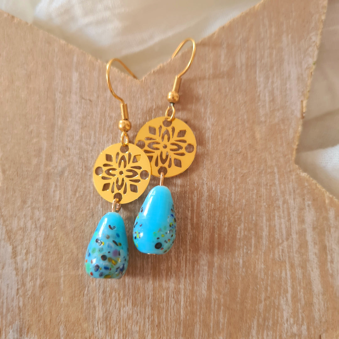 Goudkleurige one of a kind oorbellen met lichtblauwe glassteen uit India