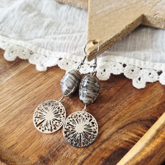 One of a kind zilverkleurige hangertjes met filigraan paardebloem bedel en grijsbruine ovale glaskraal