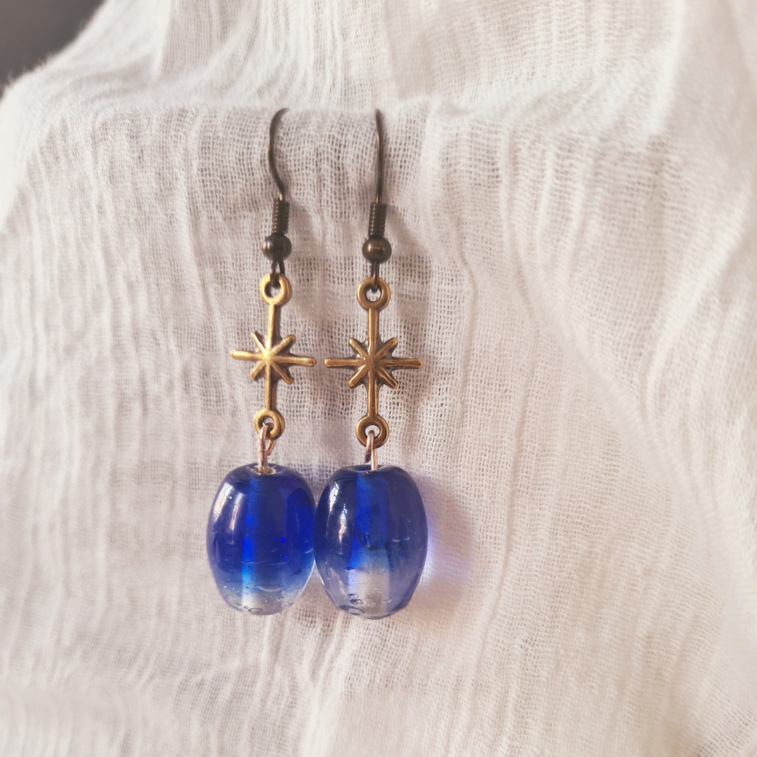 One of a kind oorbellen met kobaltblauwe glassteen en bronzen sterbedel