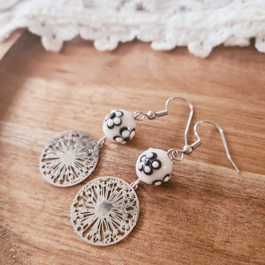 one of a kind oorbellen met zilverkleurige paardebloem bedel en glaskraal